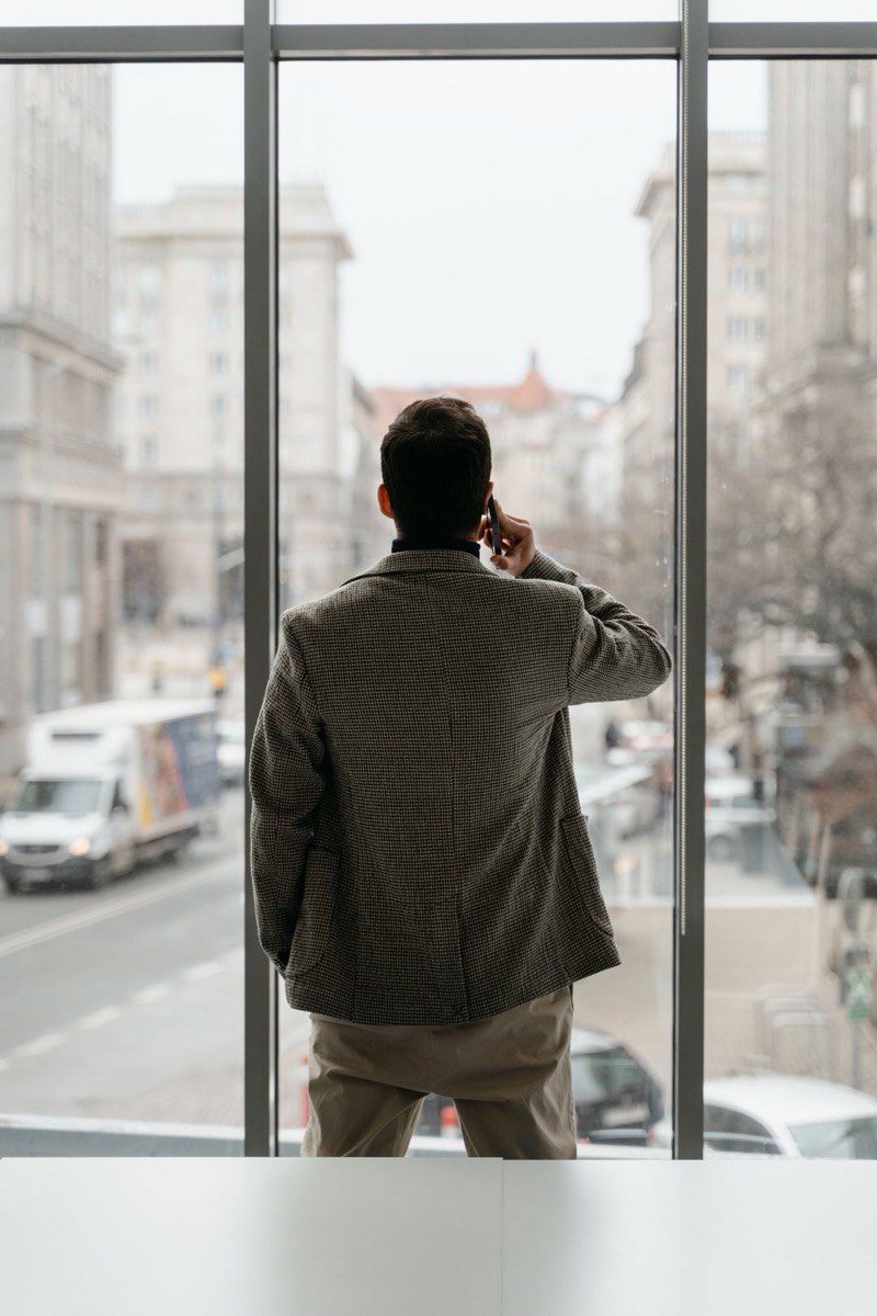 A man at work talking on the phone, seen from behind